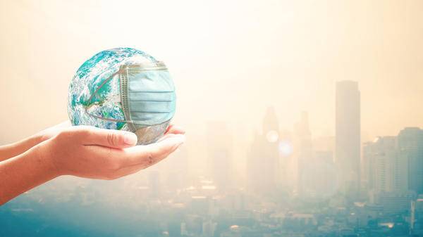 Hands holding globe wearing mask