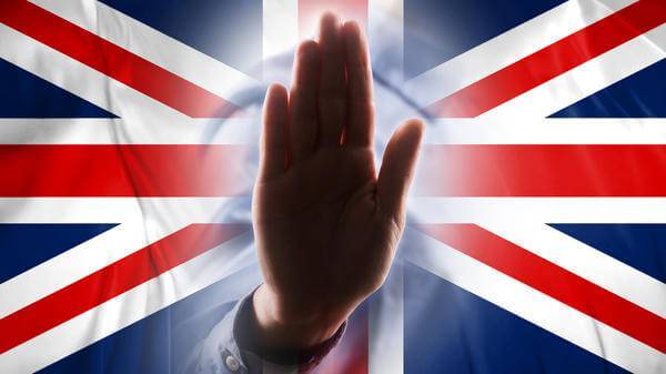 Stop sign hand in front of UK flag