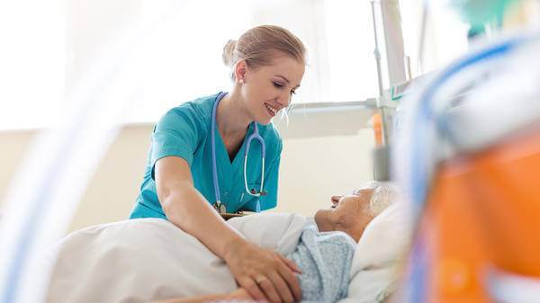Nurse comforting old woman