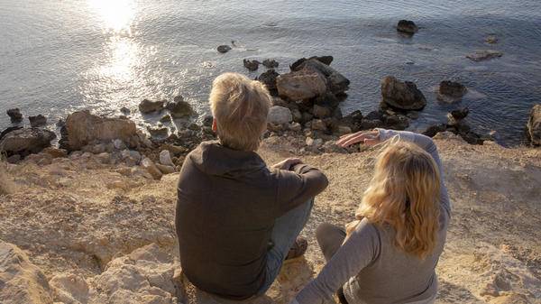 mature couple sit by the sea