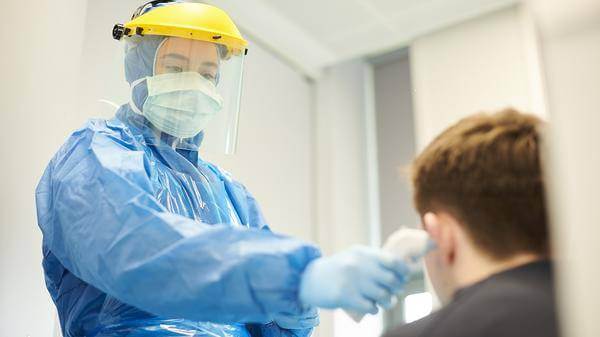 Person in PPE taking temperature