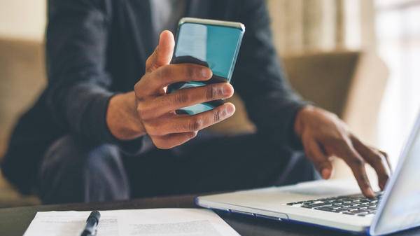 Man with smartphone and laptop