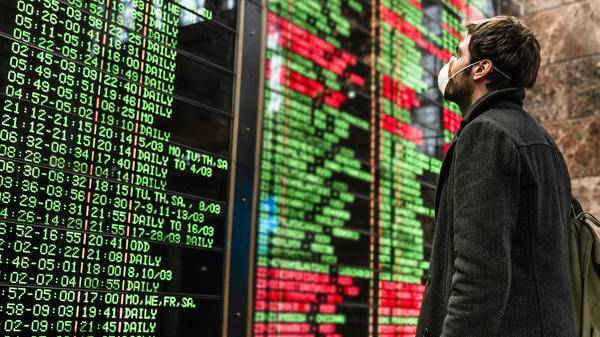 Man in mask looking at Departures board
