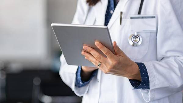 Woman doctor checking tablet