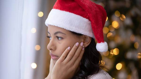 woman looking sad with santa hat