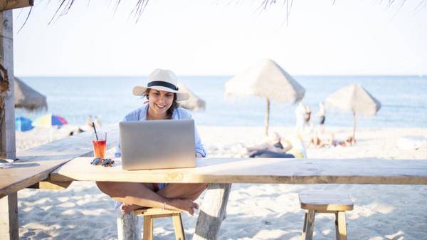 woman working on beach with laptop