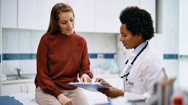 Doctor talking to patient, filling out form