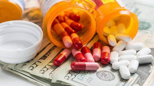 pills outside the box on top of bills