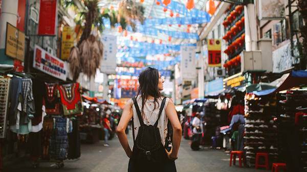 Tourist travelling with backpack down a busy street