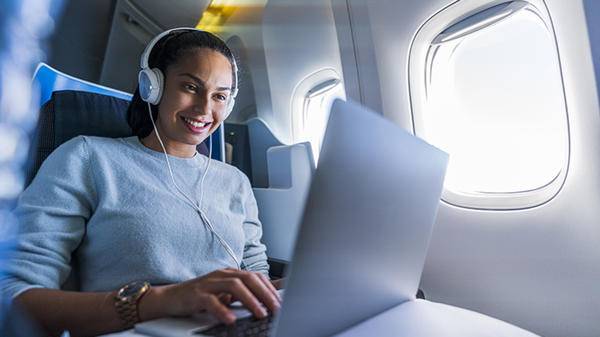 Woman using computer on plane
