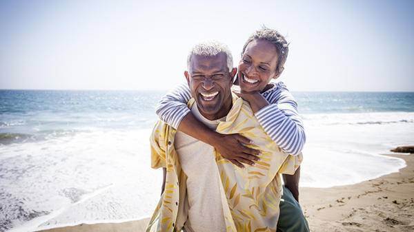 Senior couple beach laughing