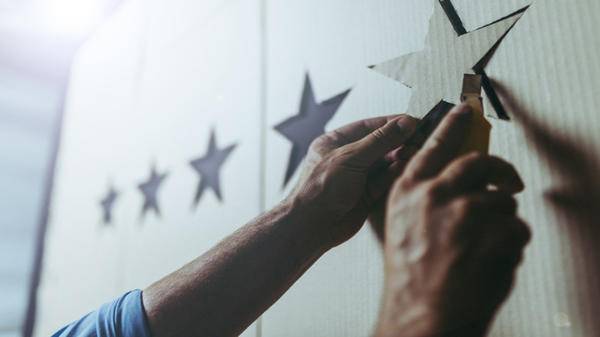 Image of hands placing cut out stars on a board
