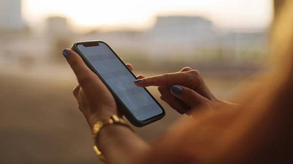 Image of person holding phone in hand with golden light