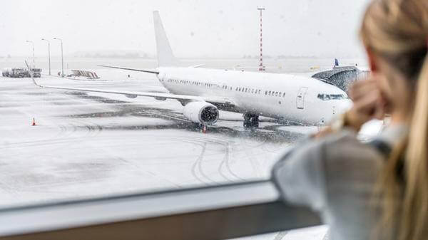 Image of girl looking out of window at a rainy runway