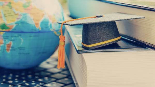 Image of graduation cap by globe