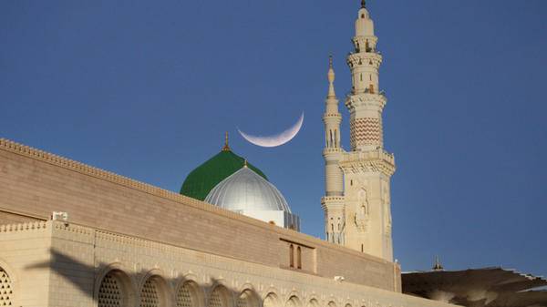 A mosque with a crescent moon in the sky