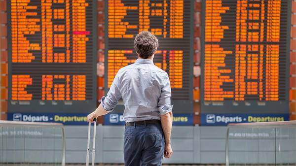 Man looking at airplane flight board