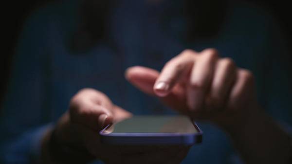 Photo of person using phone, fraud conceptual 