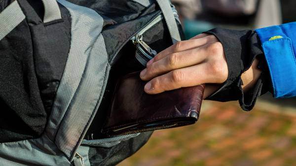 Image of purse being stolen from travellers rucksack