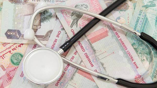 Image of medical stethoscope in front of UAE dirham