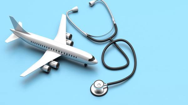 Plane model and medical stethoscope on blue background