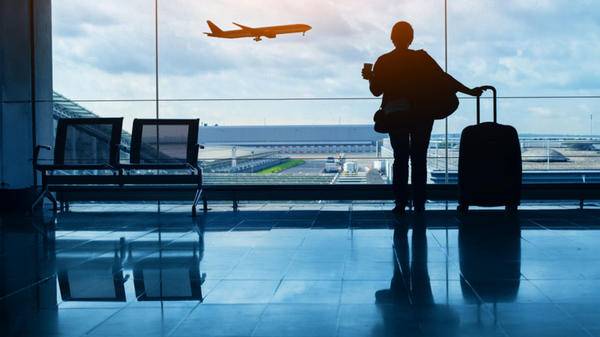 Travel by plane, woman passenger waiting in airport, silhouette of passenger in airport 