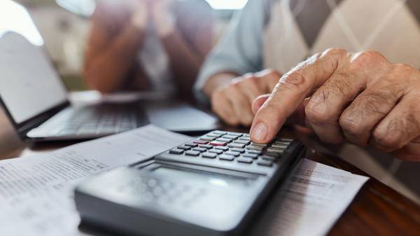 Close up of unrecognizable man calculating home finances while using calculator