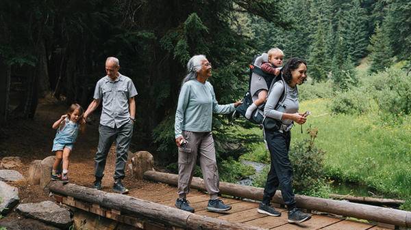 Family hiking in the forest over a bridge 