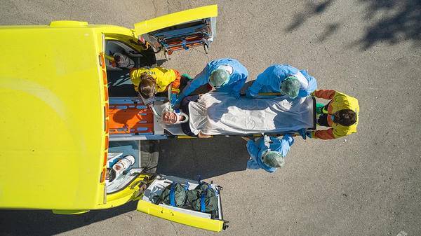 Image of person being unloaded out of an ambulance 