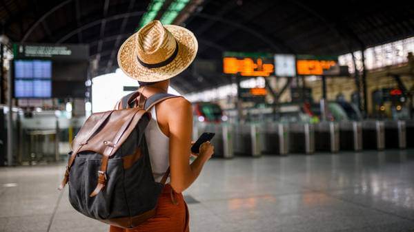 Traveller at airport looking at flight times