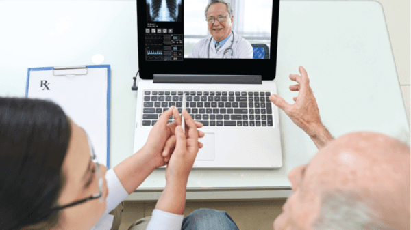 An elderly person talking to a doctor on a laptop