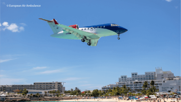 Air ambulance travelling over a beach