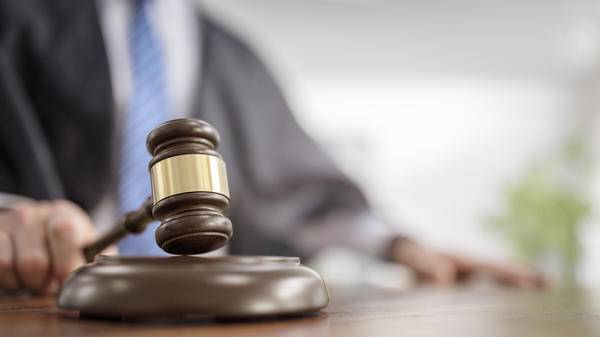 Judge holding gavel in court room giving verdict background