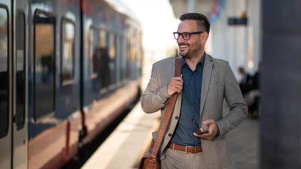 Young businessman using mobile phone at train station