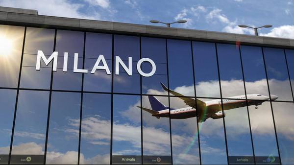 Airplane landing at Milan Italy airport mirrored in terminal 