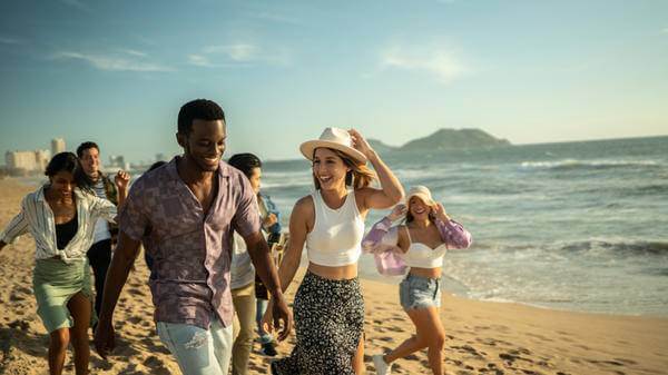Group of young friends walking along a beach 