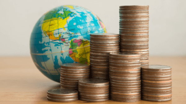 Coins stacked up next to a globe