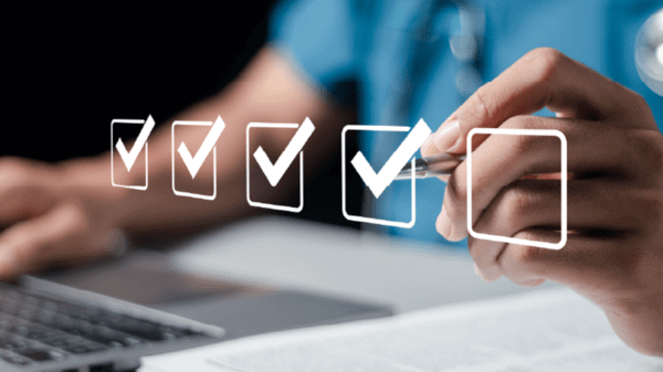Nurse ticking boxes and on a laptop
