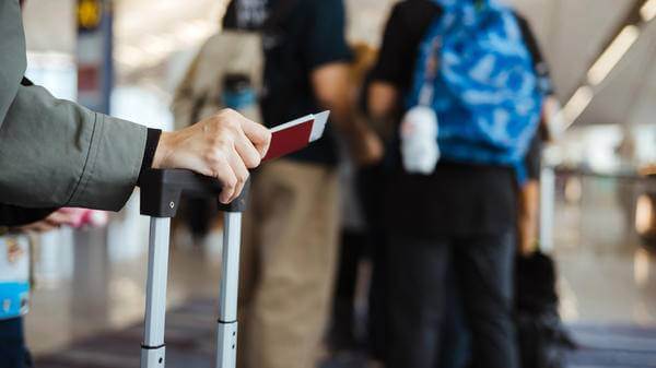 Ready For Travelling: An Unrecognizable Asian Holding Her Passport And Other Documents