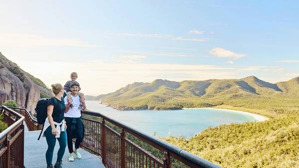 Worth the walk: Bushwalking young family in Tasmania, Australia taking in the view at Freycinet NP