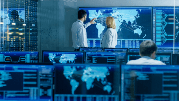 Computer screen with professionals pointing at a map