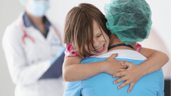 Little girl hugging doctor