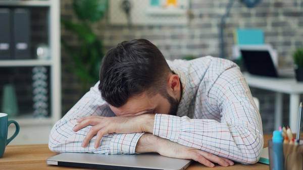Sad unwell man at office desk