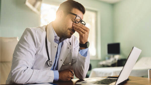Doctor struggling in front of his laptop