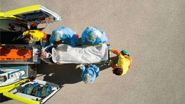 A person on a stretcher being brought into an ambulance